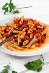 Pasta Penne, Tomato Sauce and Salmon on White Marble Table Background