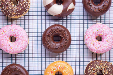 Flat lay composition of mixed donuts on white background.