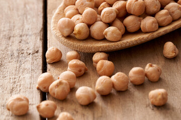 Chickpeas on wooden spoon and rustic table