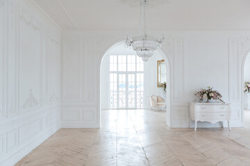 chic white huge spacious hall with a minimum of expensive antique furniture. Baroque interior...