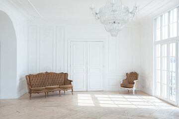 chic white huge spacious hall with a minimum of expensive antique furniture. Baroque interior...