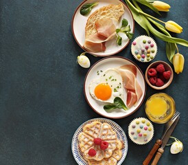 Easter breakfast table with fried egg and croissant sandwich. Flat layot, copy space
