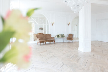 chic white huge spacious hall with a minimum of expensive antique furniture. Baroque interior...