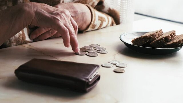 Hands of an elderly poor woman counting money, close-up