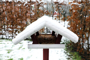 Vogelhaus mit Futter und Schnee