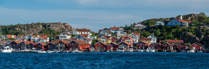 Colorful facades of Swedish summerhouse and sailing boats in harbour