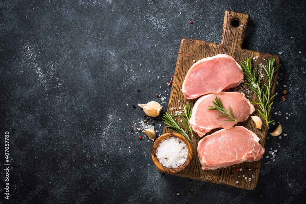 Sticker pork meat. fresh pork steaks on cutting board with ingredients for cooking. top view at black stone 