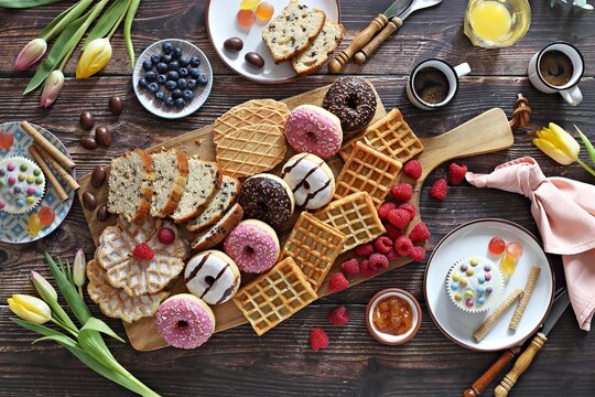 Flat layot from  festive dessert table with various of waffles, cake, muffins and sweets.