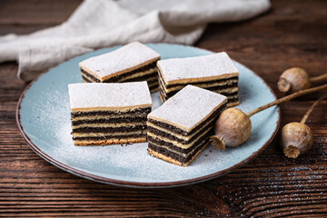 Layered poppy seed cake dusted with powdered sugar