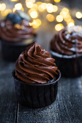 Cupcakes or muffins with chocolate cream and sweets. Cake celebration, delicious dessert, close-up