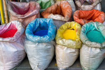Close up colored bright color pigments in bags on street market