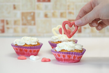 Homemade muffins for Valentine's Day. Photo 5: the girl decorates the dessert with hearts.