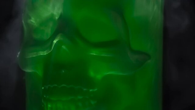 Matte Green Skull. Frosted green glass skull rotates slowly in icy vapors against black background