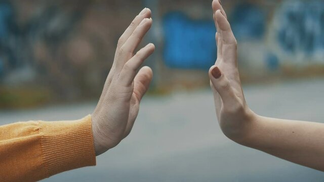 distance symbol - hands of a young couple touch each other