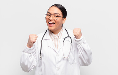 hispanic woman feeling shocked, excited and happy, laughing and celebrating success, saying wow!