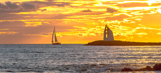 Panorama d'un coucher de soleil sur une digue avec vue sur le phare de La Grande Motte, sud de la France près de la Camargue.  © ODIN Daniel