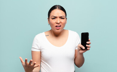 hispanic woman looking angry, annoyed and frustrated screaming wtf or what’s wrong with you