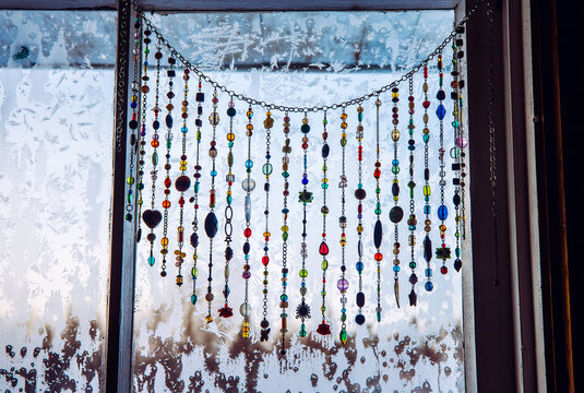 Handmade Sun Catcher With Crystals And Beading Window Curtains Hanging On Winter Frosty Window.