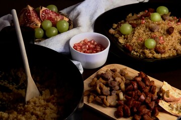 Food spanish crumbs with sausages, bacon, pomegranate and grapes