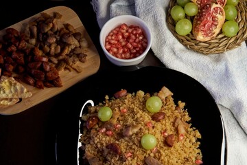 Food spanish crumbs with sausages, bacon, pomegranate and grapes