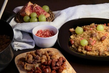 Food spanish crumbs with sausages, bacon, pomegranate and grapes