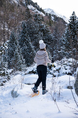 Mujer andando por la nieve, con raquetas.