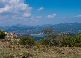 view of the National Park of Barbagia with blue lake lago Alto del Flumendosa, limestone rocks, green forest, hill and mountains. Central Sardinia, Italy, summer day