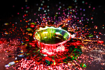 Drops of water colliding with powdered dye to create a multi coloured abstract droplet collision