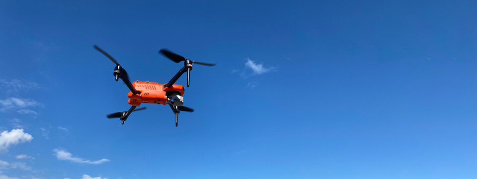 Ultra wide panoramic zoom photo of latest technology RC camera drone or UAV (unmanned aerial vehicle) on a cloudy deep blue sky