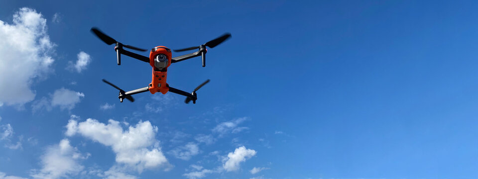 Ultra wide panoramic zoom photo of latest technology RC camera drone or UAV (unmanned aerial vehicle) on a cloudy deep blue sky