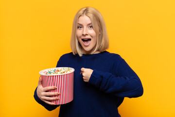 blonde woman feeling happy, positive and successful, motivated when facing a challenge or celebrating good results