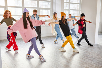 dancers performing modern dance element, preparing for concert in studio, professional group of young dancers practicing moves