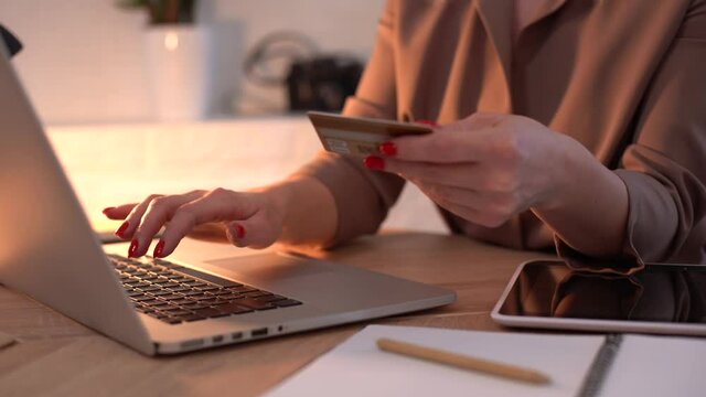 Female hands typing credit card number on computer keyboard. Woman making online purchase. Online payment service.