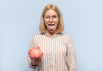 blonde woman with cheerful, carefree, rebellious attitude, joking and sticking tongue out, having...