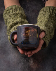 Hand made cup in female hands, dark photo - 407068113