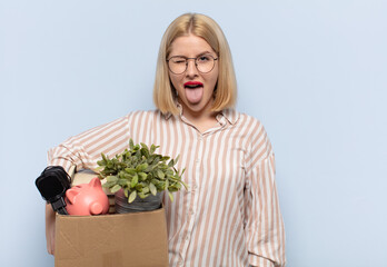 blonde woman with cheerful, carefree, rebellious attitude, joking and sticking tongue out, having...