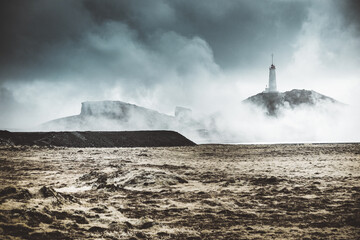 Fototapeta na wymiar Lighthouse in a foggy day. Cloudy landscape.
