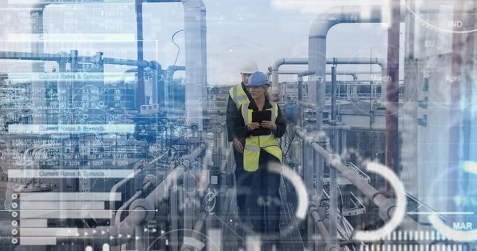 Industrial workers inspecting industrial plant using digital tablet technology and wearing protective workwear