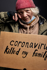 outcast woman hold cadboard in hands, she lost her family due to coronavirus, needs shelter and...