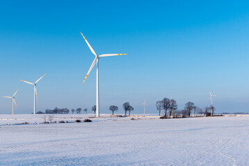 Windmills for electric power production. Winter landscape in northern Poland. Europe