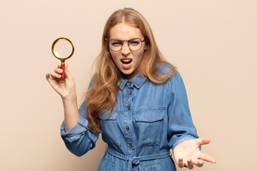 blonde woman looking angry, annoyed and frustrated screaming wtf or what’s wrong with you