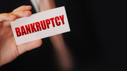 Bankruptcy on a card. Businessman holding a card with word Bankruptcy. Crisis business closing...