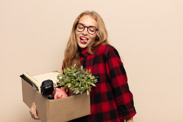 blonde woman with cheerful, carefree, rebellious attitude, joking and sticking tongue out, having...
