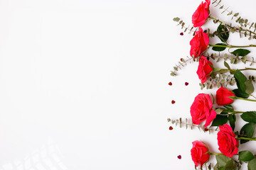 Flowers composition. Frame made of red rose flowers on white background. Flat lay, top view, copy space