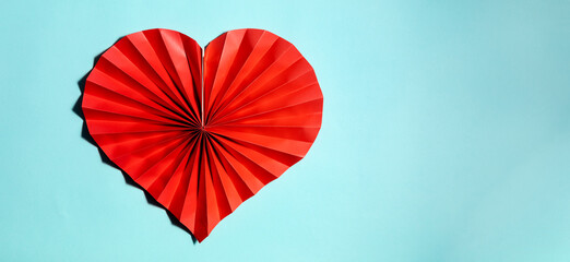 Red paper heart on pastel blue background