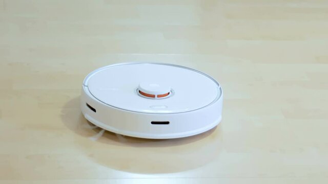 A moving vacuum cleaner on the floor of the living room of hte house in Estonia