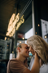 Happy to be in love. Beautiful young couple sitting face to face and smiling while relaxing near a coffee shop