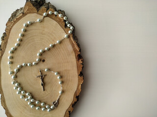 Catholic rosary prayer on a wooden saw cut birch.