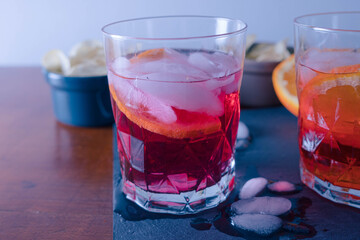 Two spritz with some chips on the table ready for the aperitif, the red one is mixed with Campari. One sprtiz is mixed with aperol and one with campari. High quality photo