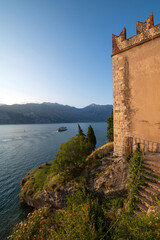 Naklejka premium Lake Garda from Malcesine seen from the castle with the reflections of the sun on its waters on a hot day in late summer. Beautiful and romantic sunset. Verona, Veneto, Italy.